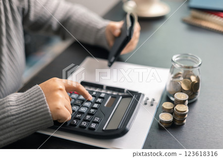 Finance bank tax expense accounting budget money businessman hand use calculator Financial calculate accountant close up calculator with graph chart write office desk Business expense analysis saving 123618316
