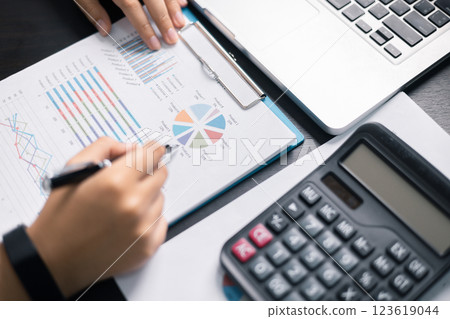 Finance bank tax expense accounting budget money businessman hand use calculator Financial calculate accountant close up calculator with graph chart write office desk Business expense analysis saving 123619044