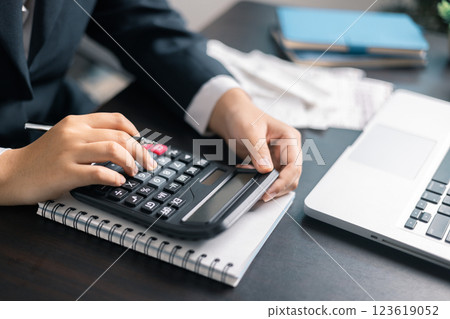 Finance bank tax expense accounting budget money businessman hand use calculator Financial calculate accountant close up calculator with graph chart write office desk Business expense analysis saving 123619052