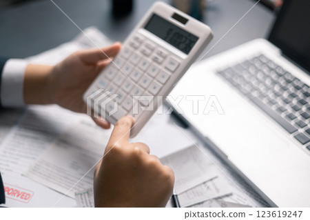Finance bank tax expense accounting budget money businessman hand use calculator Financial calculate accountant close up calculator with graph chart write office desk Business expense analysis saving 123619247