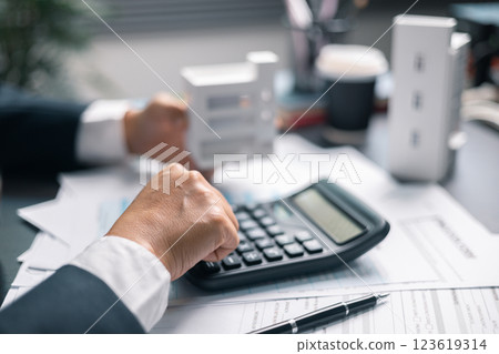 Finance bank tax expense accounting budget money businessman home for Business expense analysis saving use Financial calculate accountant close up calculator with graph chart hand write office desk 123619314
