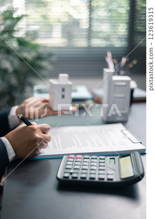 Finance bank tax expense accounting budget money businessman home for Business expense analysis saving use Financial calculate accountant close up calculator with graph chart hand write office desk 123619315