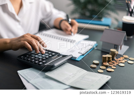 Finance bank tax expense accounting budget money businessman home for Business expense analysis saving use Financial calculate accountant close up calculator with graph chart hand write office desk 123619319