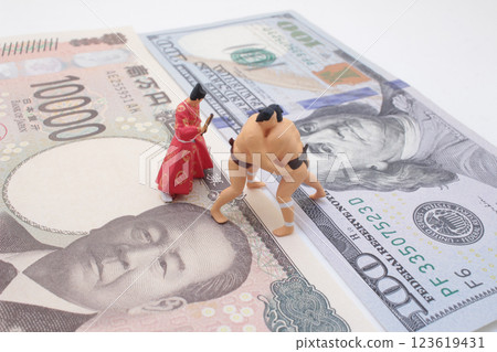 Miniature Figures of Sumo Wrestlers and Money Representing Economic Competition Miniature Figures of Sumo Wrestlers and Money Representing Economic Competition 123619431