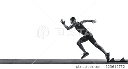 Dynamic photo of young athletic man, professional runner runs up quickly in action against white studio background. Monochrome filter. 123619752