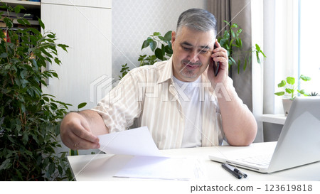 Man Smiling While Talking on Phone at Desk 123619818