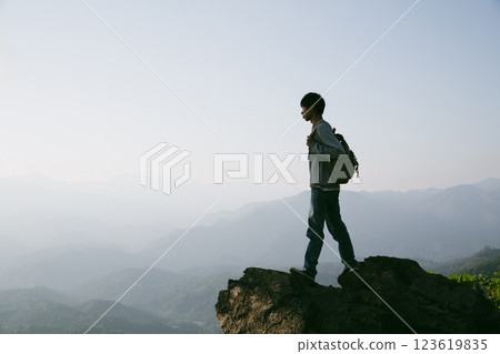 Man traveler with camera backpack hiking outdoor travel lifestyle and adventure concept. cap backpack and join of tourist for green mountain tour, beauty of nature and expansive sky people of tourism 123619835