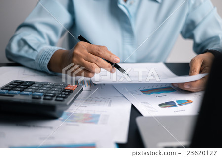 Finance bank tax expense accounting budget money businessman hand use calculator Financial calculate accountant close up calculator with graph chart write office desk Business expense analysis saving 123620127