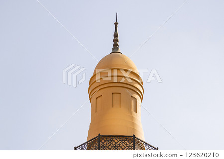 Sand-colored minaret of a Muslim mosque against sky background Sand-colored minaret of a Muslim mosque against sky background 123620210