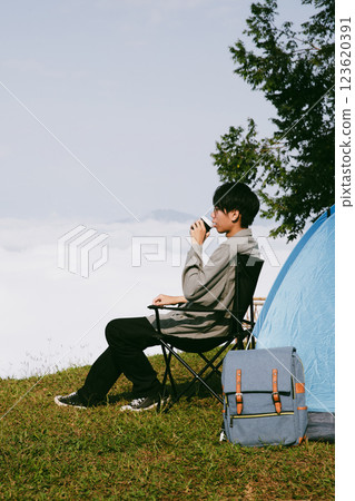 Man traveler with camera backpack hiking outdoor travel lifestyle and adventure concept. cap backpack and join of tourist for green mountain tour, beauty of nature and expansive sky people of tourism Man traveler with camera backpack hiking outdoor travel lifestyle and adventure concept. cap backpack and join of tourist for green mountain tour, beauty of nature and expansive sky people of tourism 123620391
