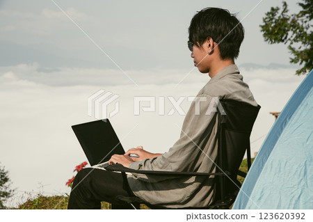Young business man working computer on peak hill. Hiker online shopping on laptop at sunset, sunrise on top mountain, freelance person remote work with digital tablet. travel vacation holiday concept Young business man working computer on peak hill. Hiker online shopping on laptop at sunset, sunrise on top mountain, freelance person remote work with digital tablet. travel vacation holiday concept 123620392