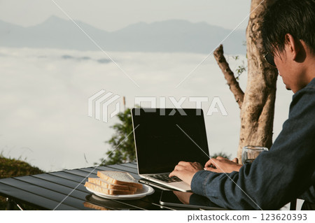 Young business man working computer on peak hill. Hiker online shopping on laptop at sunset, sunrise on top mountain, freelance person remote work with digital tablet. travel vacation holiday concept Young business man working computer on peak hill. Hiker online shopping on laptop at sunset, sunrise on top mountain, freelance person remote work with digital tablet. travel vacation holiday concept 123620393