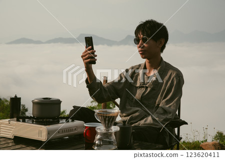 Young business man working computer on peak hill. Hiker online shopping on laptop at sunset, sunrise on top mountain, freelance person remote work with digital tablet. travel vacation holiday concept 123620411