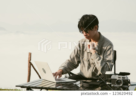 Young business man working computer on peak hill. Hiker online shopping on laptop at sunset, sunrise on top mountain, freelance person remote work with digital tablet. travel vacation holiday concept Young business man working computer on peak hill. Hiker online shopping on laptop at sunset, sunrise on top mountain, freelance person remote work with digital tablet. travel vacation holiday concept 123620492