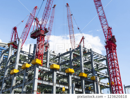 Low-angle view of cranes and steel structures of building construction with a blue sky background in Taiwan. 123620818