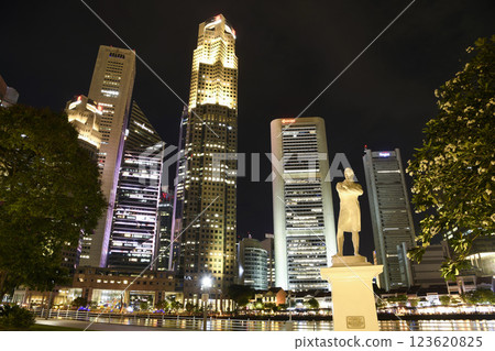 Night view of the statue of Sir Stamford Raffles with a skyscraper background on the bank of the Singapore River. here is Sir Raffles's Landing Site.  123620825