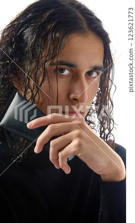 Close-up of handsome young man with black skincare product, with intense gaze against white studio background. 123621773