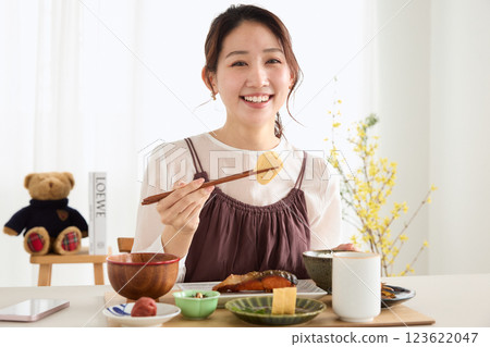 Woman eating breakfast in the dining room 123622047