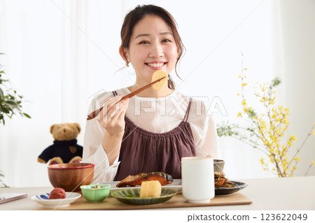 Woman eating breakfast in the dining room Woman eating breakfast in the dining room 123622049