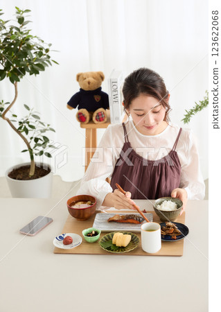Woman eating breakfast in the dining room Woman eating breakfast in the dining room 123622068