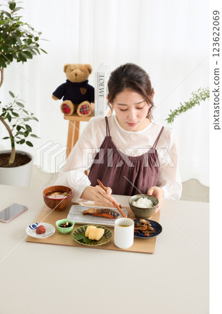 Woman eating breakfast in the dining room Woman eating breakfast in the dining room 123622069
