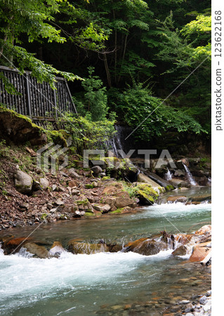 A river flowing through a mountain valley A river flowing through a mountain valley 123622168