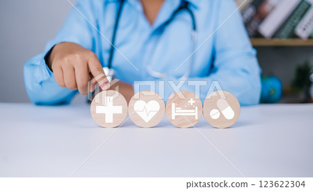 Health and access to welfare health concept, Health insurance concept, Doctor hand point wooden planks arranged in rows with hospital icons and healthcare medical on table, Treatment of disease. 123622304