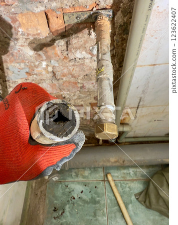 Conducting an inspection of a corroded pipe that highlights the urgent need for specific plumbing repairs 123622407