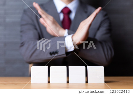 一位中年男性商人用四塊白色木塊做十字標誌 123622413