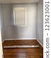Small empty bed room with rolled up rug on floor  123623001