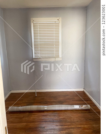 Small empty bed room with rolled up rug on floor Small empty bed room with rolled up rug on floor 123623001