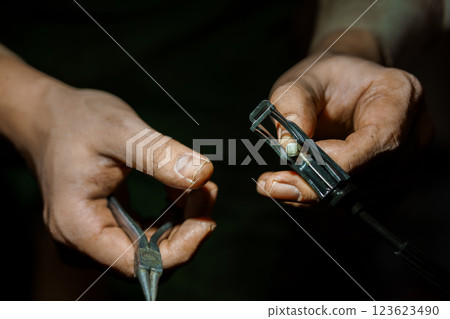 Skilled Artisan Repairing Mechanical Component with Precision Tools 123623490
