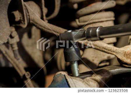 Close-up of Mechanic Using Torque Wrench to Tighten Bolt on Vehicle Suspension System 123623506