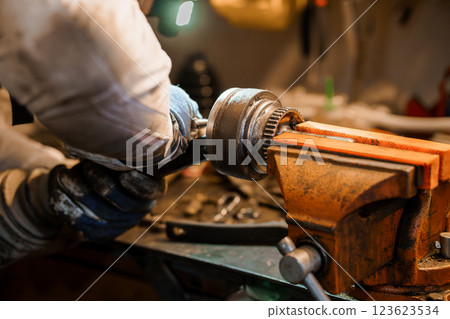 Detailed Close-Up of Mechanic Working on Engine Parts in a Workshop Detailed Close-Up of Mechanic Working on Engine Parts in a Workshop 123623534
