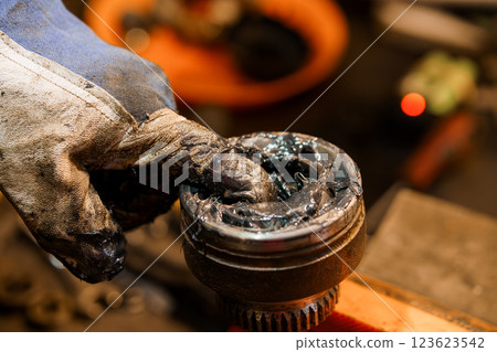 Close-Up of Gloved Hand Applying Grease to Mechanical Bearing Component Close-Up of Gloved Hand Applying Grease to Mechanical Bearing Component 123623542