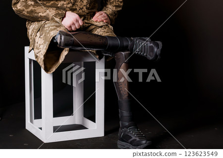 Soldier Seated with Advanced Bionic Leg Prosthesis, Showcasing Modern Technology and Camouflage Uniform 123623549
