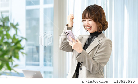 一位女士/女商人正在看她的智慧型手機並豎起大拇指 一位女士/女商人正在看她的智慧型手機並豎起大拇指 123623689