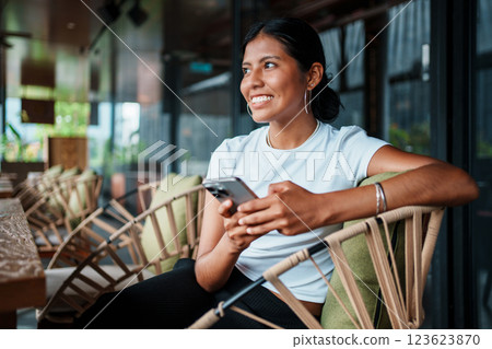 Smiling Woman Using Smartphone in Modern Caf 123623870