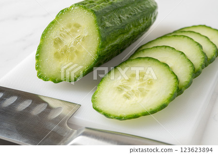 Cut in half cucumber, juicy slices and kitchen knife close-up. Cut in half cucumber, juicy slices and kitchen knife close-up. 123623894