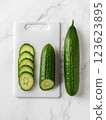 Raw green cucumbers on a white cutting board. 123623895