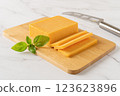 Sheddar cheese slices on a cutting board. 123623896