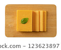Sheddar cheese slices on a cutting board cutout. 123623897