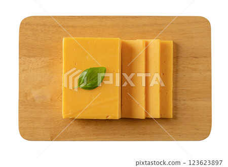 Sheddar cheese slices on a cutting board cutout. 123623897