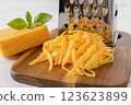 Whole and grated cheddar cheese close-up. 123623899