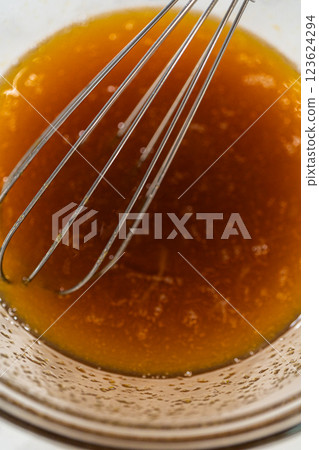 Wet ingredients including maple syrup and two eggs in a glass bowl for Pale Gingerbread Cookies. Ready for mixing. 123624294