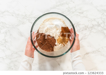 Top view of a bowl containing flour and spices for Chocolate Ginger Sugar Cookie Dough, highlighting key ingredients like ginger and cocoa powder. Top view of a bowl containing flour and spices for Chocolate Ginger Sugar Cookie Dough, highlighting key ingredients like ginger and cocoa powder. 123624333