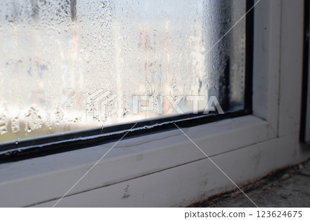 water flows through the window. condensation and humidity in the room 123624675