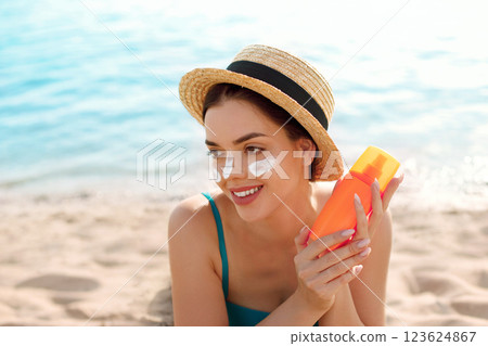 Beautiful woman applying cream sunscreen on tanned face. Sunscreen. Skin and body care. Beautiful woman applying cream sunscreen on tanned face. Sunscreen. Skin and body care. 123624867