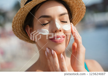 Woman smile applying sun cream on face. Skincare. Body Sun protection. sunscreen. Woman smile applying sun cream on face. Skincare. Body Sun protection. sunscreen. 123624887