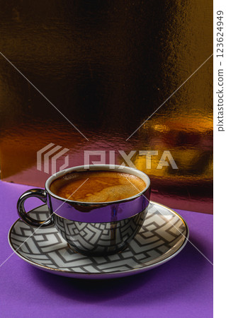 Elegant coffee cup rests on a vibrant purple surface with a shiny background Elegant coffee cup rests on a vibrant purple surface with a shiny background 123624949